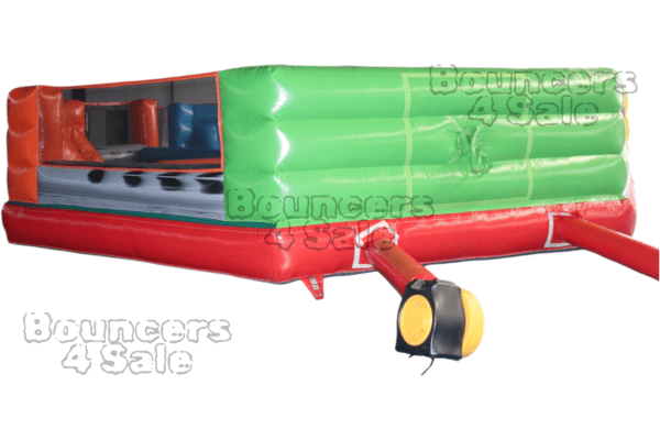 A green and red inflatable obstacle course with a light.