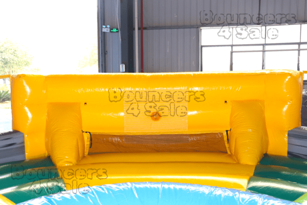 A yellow and blue inflatable slide in the sun.