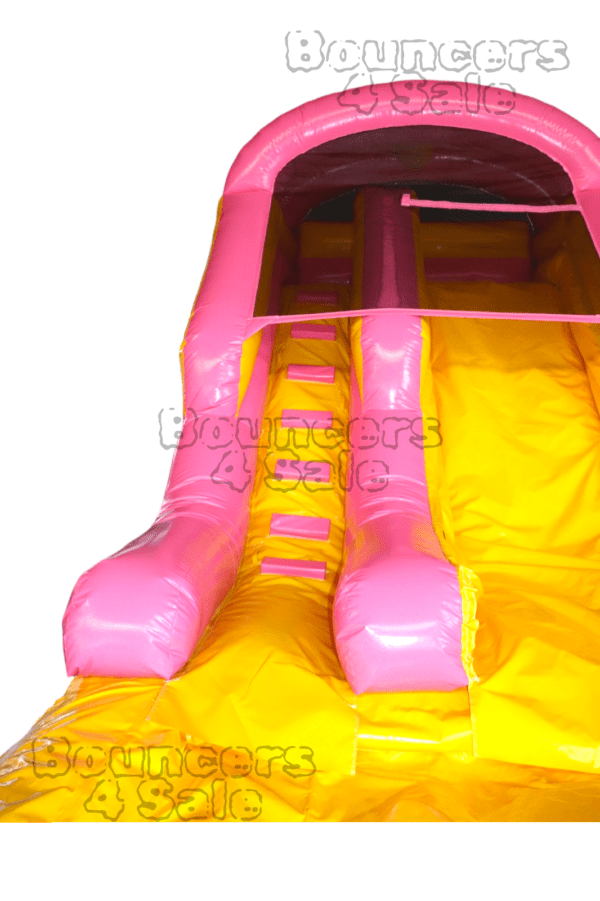 A pink and yellow inflatable slide with obstacles.