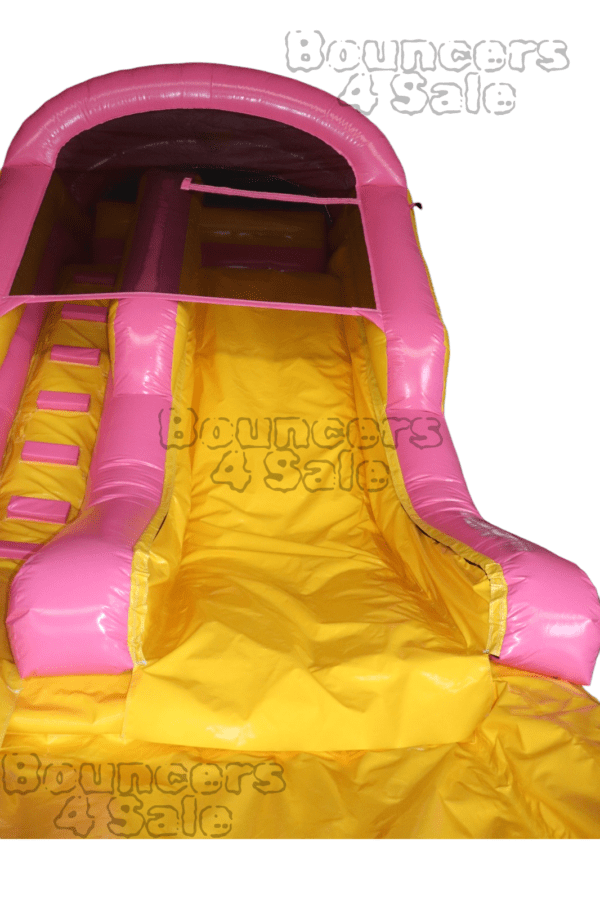 A pink and yellow inflatable slide with obstacles.