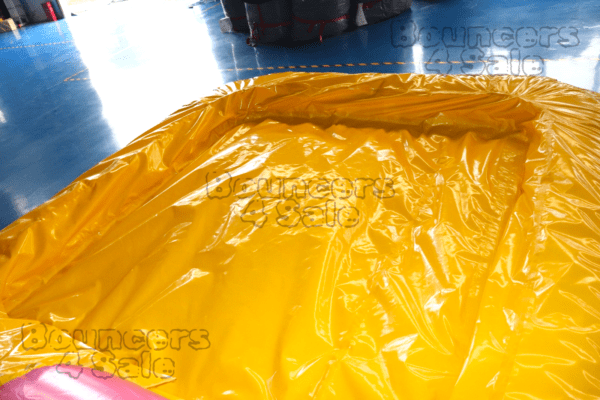 A yellow inflatable slide with a blue floor.