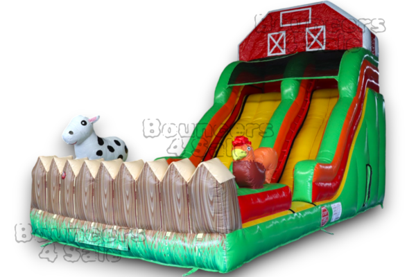 A inflatable slide with farm animals and fence.