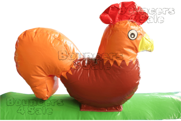 A large inflatable chicken is sitting on the grass.