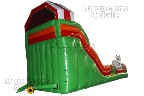 A green and red inflatable slide with a horse on it.