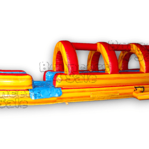 A long inflatable slide with obstacles on it.