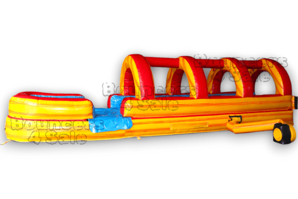 A long inflatable slide with obstacles on it.