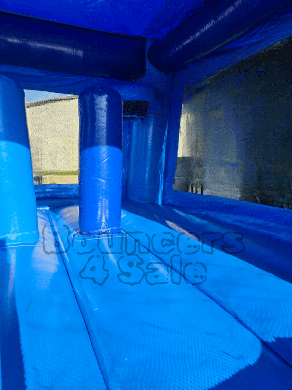 A blue inflatable castle with two pillars and a slide.