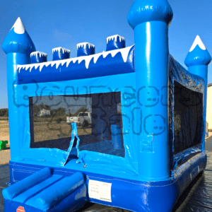 A blue inflatable castle with snow on it.