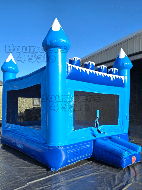 A blue inflatable castle with snow on it.