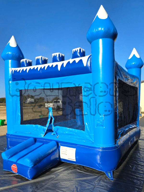 A blue inflatable castle with snow on it.