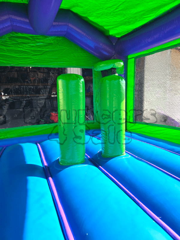 A blue and green bouncy castle with two pillars.