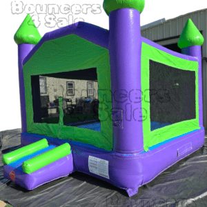 A purple and green bounce house with steps.