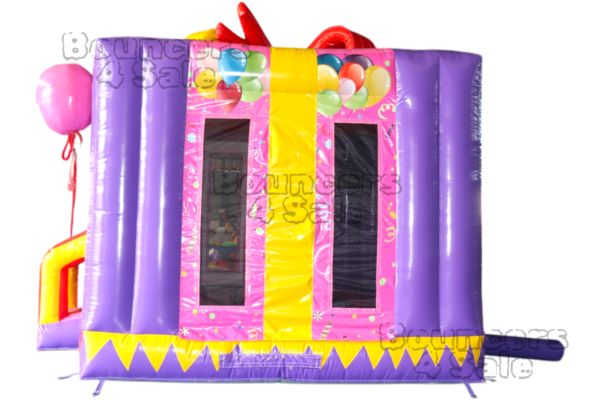 A purple and yellow inflatable castle with balloons on it.