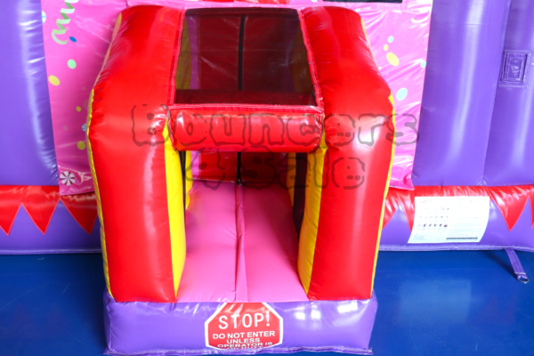 A pink and red inflatable castle with a slide.