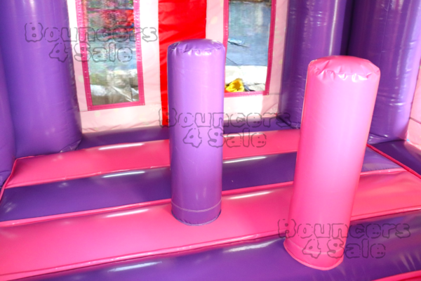 A pink and purple inflatable castle with two pillars.